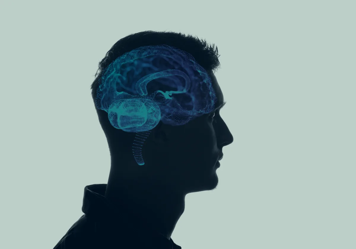 A man in profile beside a rendered illustration of the human brain