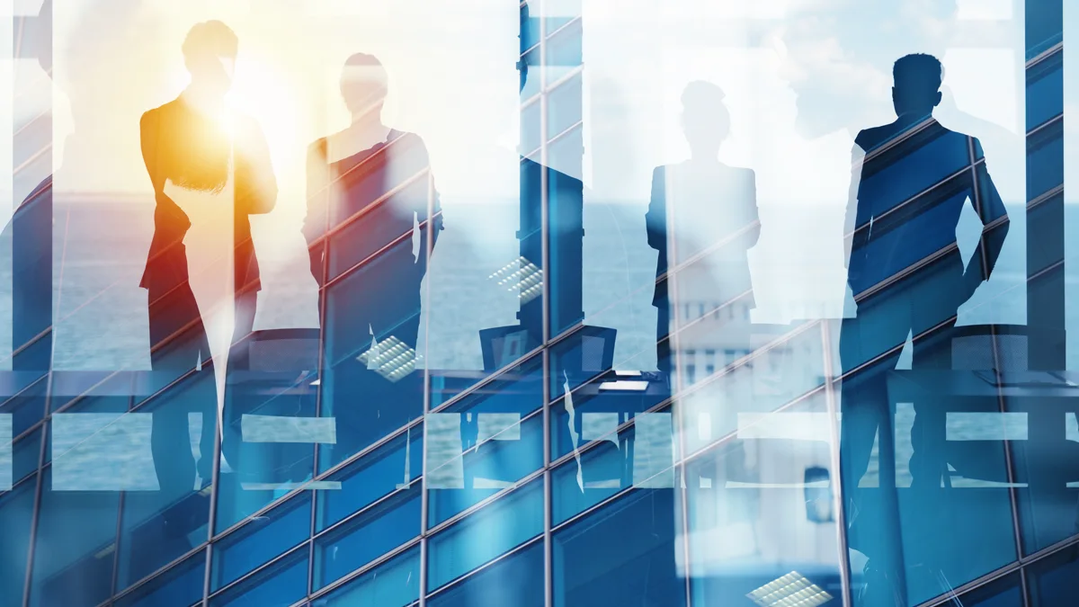 Business team silhouetted in a sunlit glass office tower